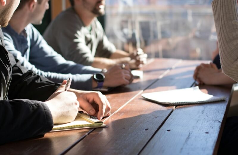 People taking notes around a meeting table