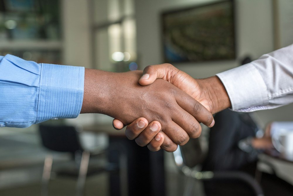 Two people shaking hands on a service agreement